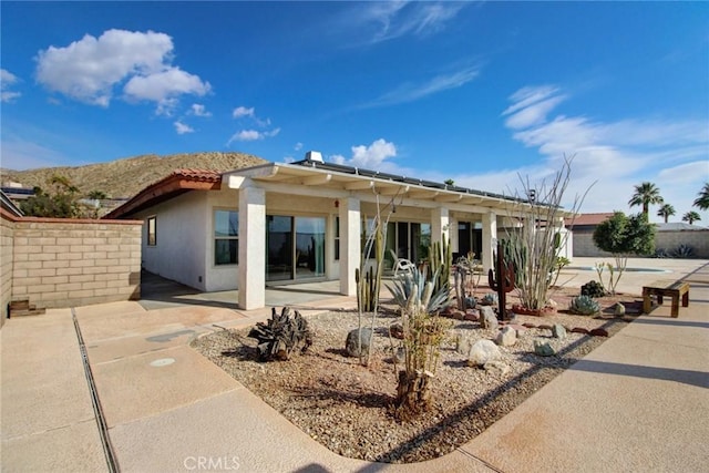 rear view of property with a mountain view and a patio