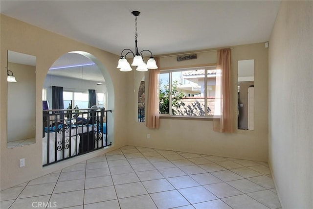 tiled empty room featuring a chandelier