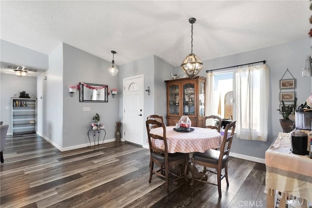 dining room featuring dark wood-type flooring and lofted ceiling