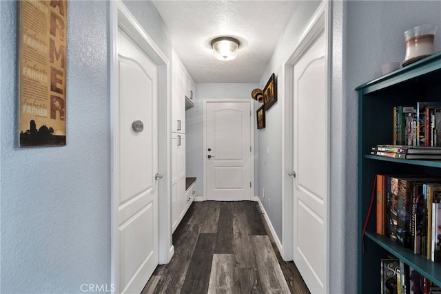 hallway featuring a textured ceiling and dark hardwood / wood-style flooring