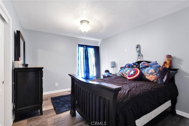 bedroom with hardwood / wood-style flooring and a textured ceiling