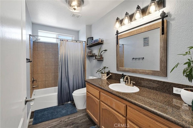 full bathroom featuring vanity, wood-type flooring, shower / bath combo with shower curtain, and toilet