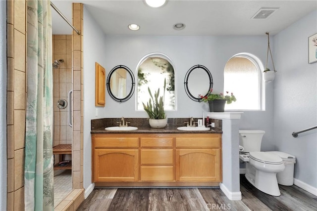 bathroom featuring hardwood / wood-style flooring, vanity, a shower with shower curtain, and toilet