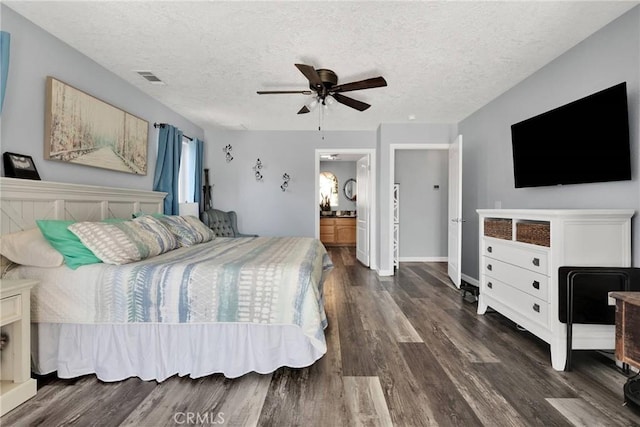 bedroom featuring ceiling fan, connected bathroom, dark hardwood / wood-style flooring, and a textured ceiling