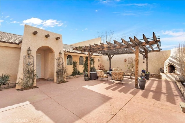 view of patio / terrace featuring exterior fireplace and a pergola