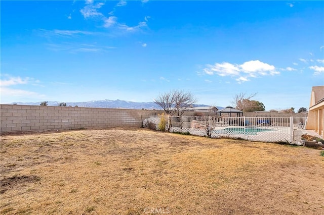 view of yard featuring a fenced in pool and a mountain view