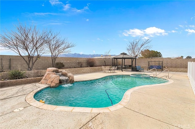 view of swimming pool with a mountain view, a gazebo, a patio area, and pool water feature