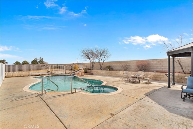 view of swimming pool with pool water feature and a patio area