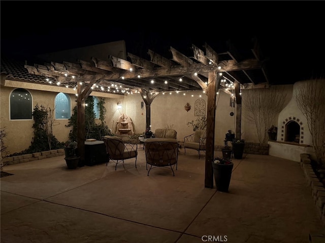 patio at twilight featuring exterior fireplace