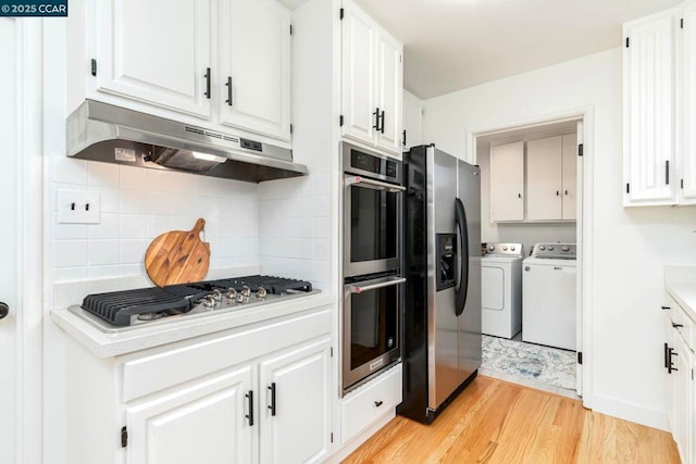 kitchen with stainless steel appliances, independent washer and dryer, tasteful backsplash, light hardwood / wood-style floors, and white cabinets