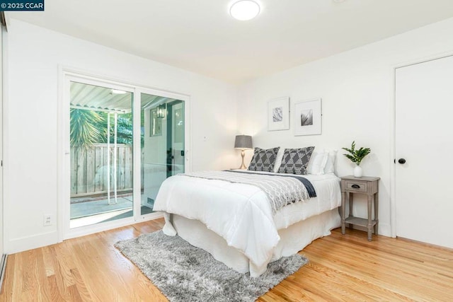 bedroom featuring wood-type flooring and access to exterior