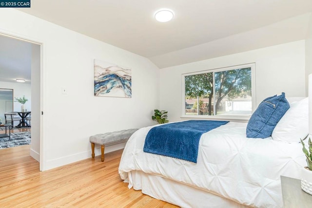 bedroom featuring hardwood / wood-style flooring and vaulted ceiling