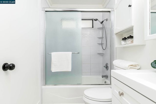 full bathroom featuring bath / shower combo with glass door, vanity, crown molding, and toilet