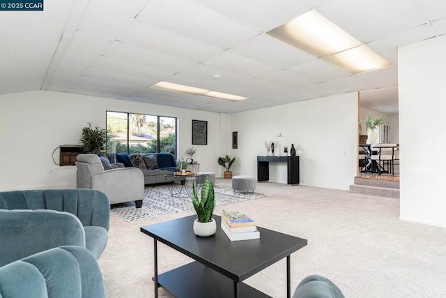 living room with a drop ceiling and carpet floors