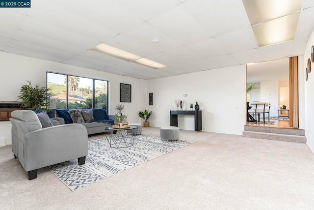 carpeted living room with a paneled ceiling