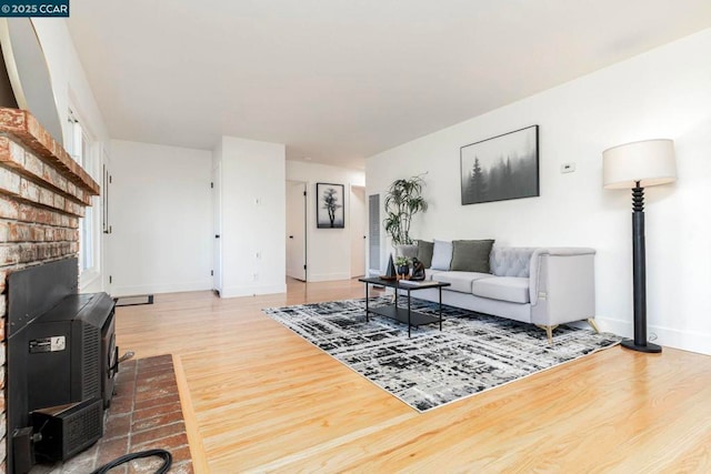 living room with a wood stove and hardwood / wood-style floors