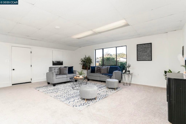 living room with a paneled ceiling and carpet flooring