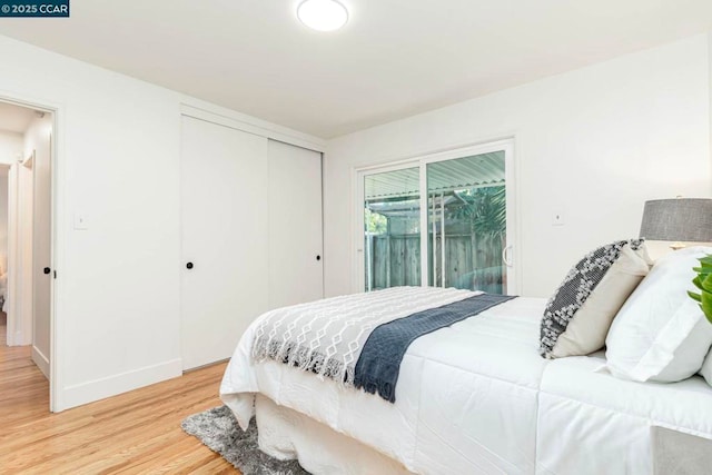 bedroom featuring wood-type flooring, a closet, and access to outside