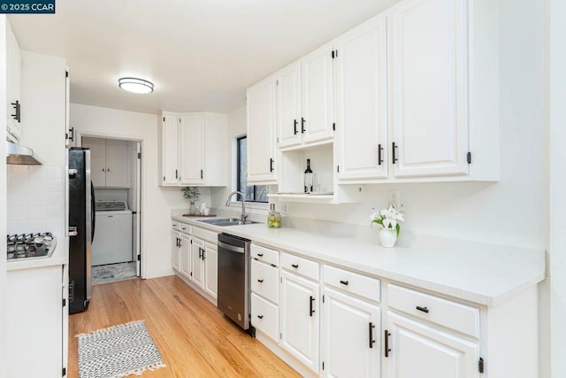 kitchen with stainless steel appliances, washer / clothes dryer, sink, and white cabinets