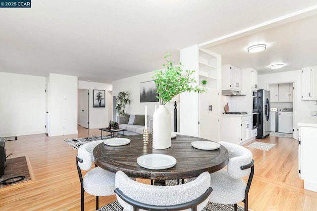 dining space featuring independent washer and dryer and light wood-type flooring