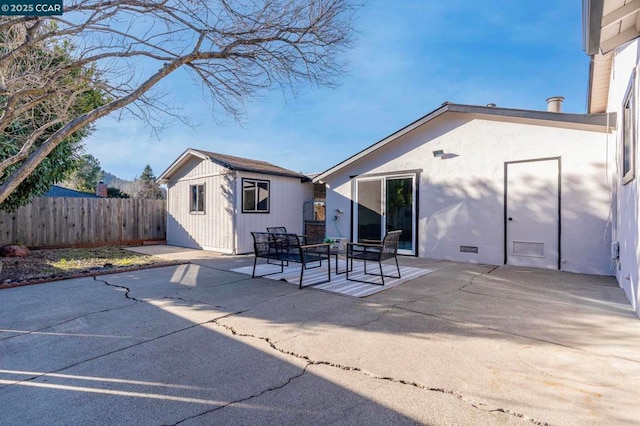 rear view of house with an outbuilding and a patio