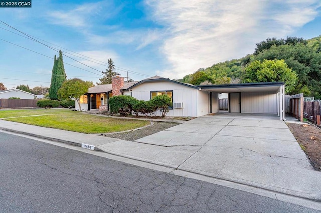 view of front of house with a carport and a front lawn