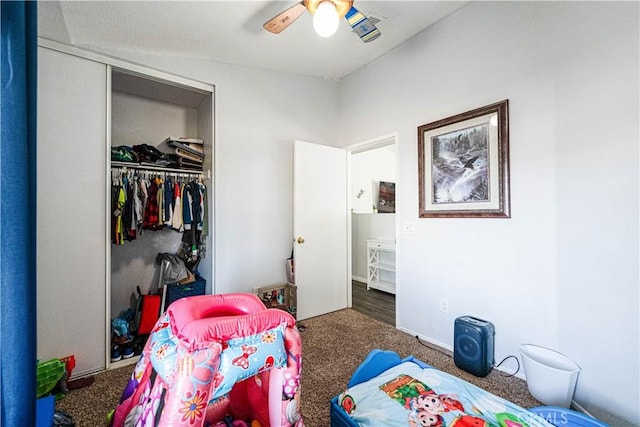 bedroom with ceiling fan, dark carpet, and a closet