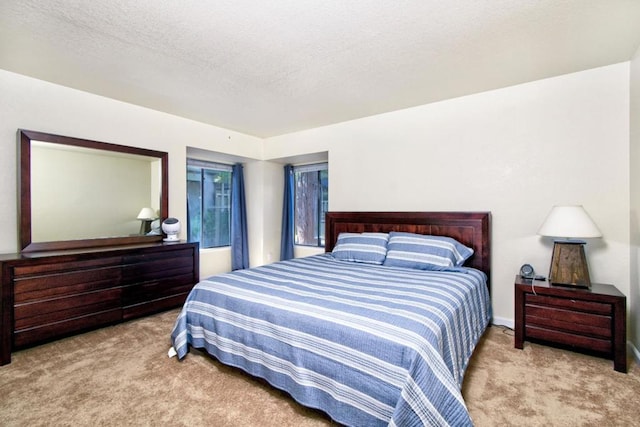 bedroom featuring light carpet and a textured ceiling