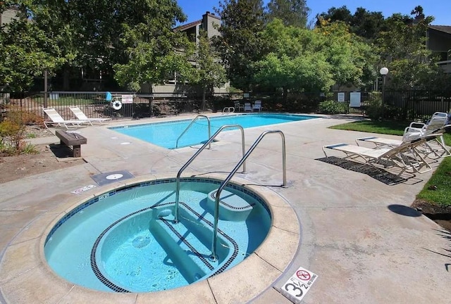 view of swimming pool with a patio area and a hot tub