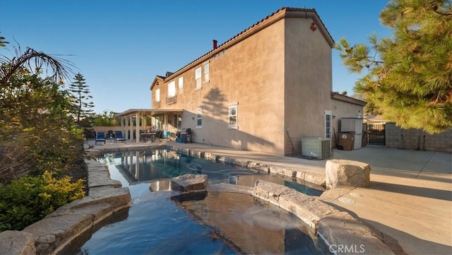 view of pool with an in ground hot tub, central AC unit, and a patio area