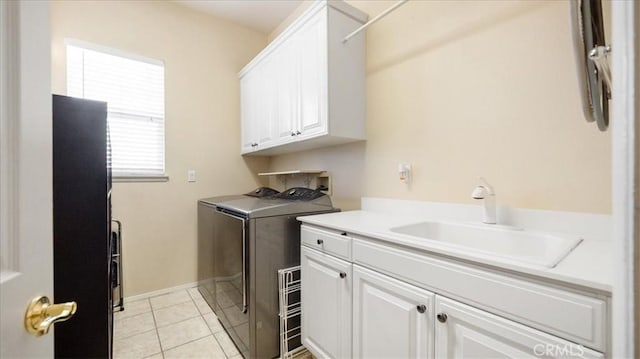 laundry room featuring independent washer and dryer, cabinets, sink, and light tile patterned floors