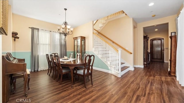 dining space with dark hardwood / wood-style flooring and a chandelier