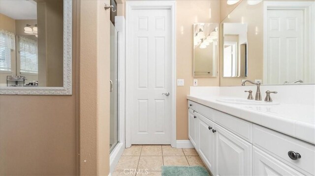 bathroom with tile patterned flooring, vanity, and an enclosed shower