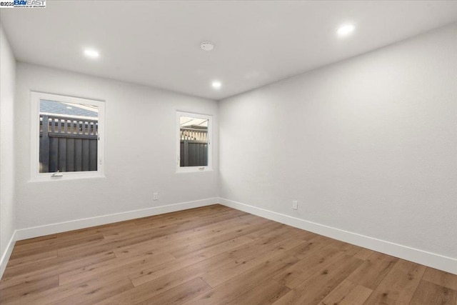 spare room with a wealth of natural light and light wood-type flooring