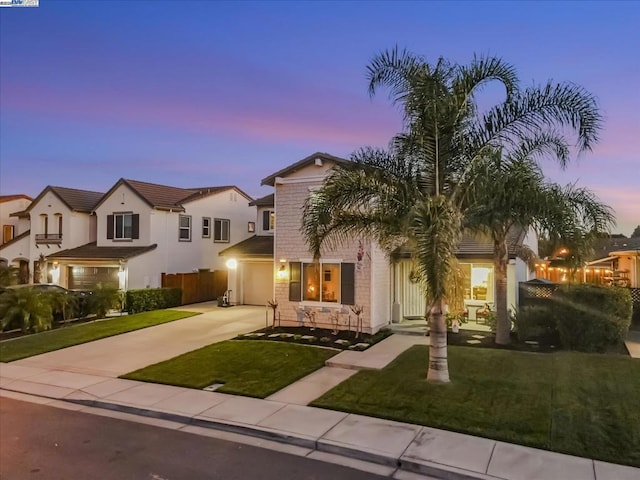 mediterranean / spanish-style house with a garage and a yard