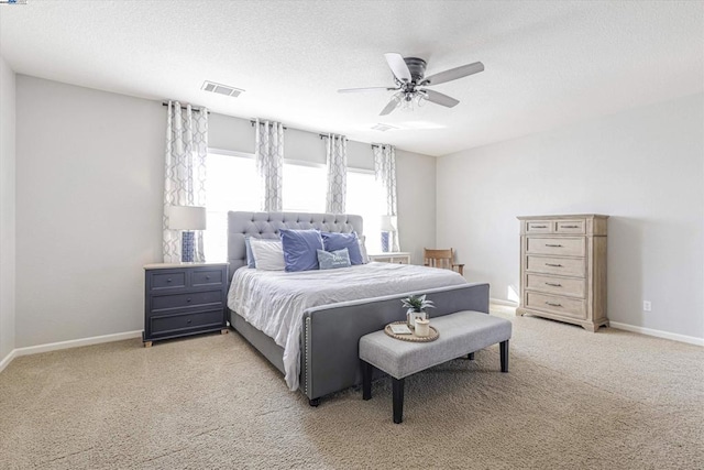 bedroom with light carpet, a textured ceiling, and ceiling fan