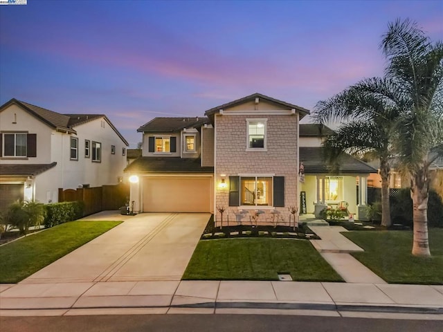 view of front of property with a garage and a yard