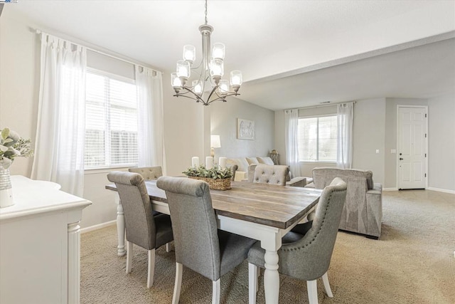 dining room featuring light colored carpet and a notable chandelier