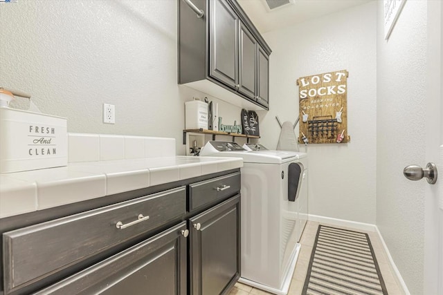 laundry room with cabinets and washing machine and clothes dryer