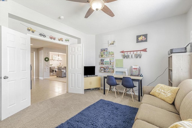 carpeted home office featuring ceiling fan with notable chandelier