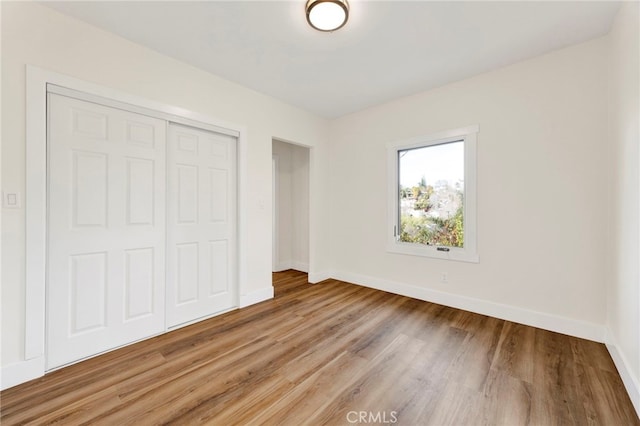 unfurnished bedroom featuring light hardwood / wood-style flooring and a closet