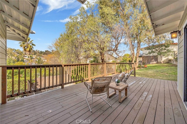 wooden terrace featuring a fire pit and a lawn