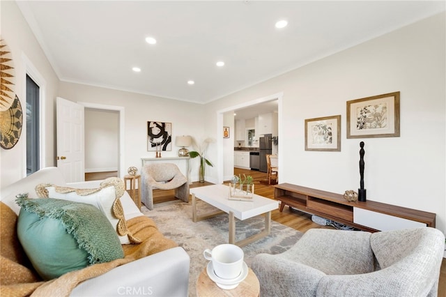 living room with crown molding and light hardwood / wood-style flooring