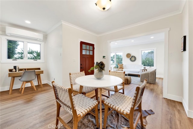 dining area featuring ornamental molding, an AC wall unit, and light wood-type flooring