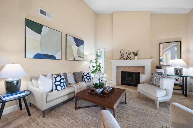 living room with a tiled fireplace and a high ceiling