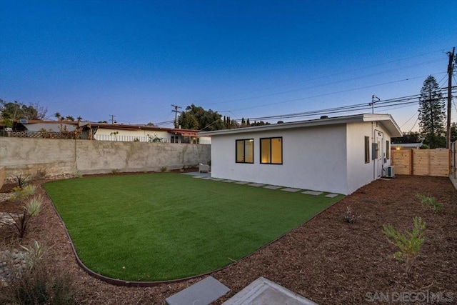 rear view of house with a lawn and central air condition unit