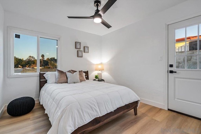 bedroom featuring multiple windows, ceiling fan, and light wood-type flooring