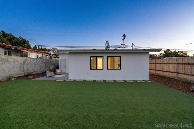 back of property with a patio and a lawn