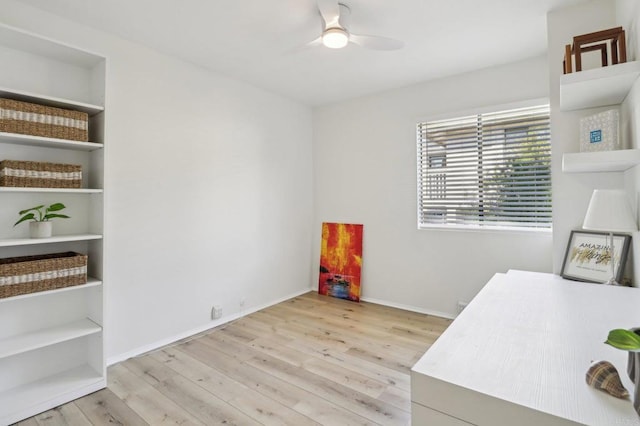 office with built in shelves, light hardwood / wood-style floors, and ceiling fan