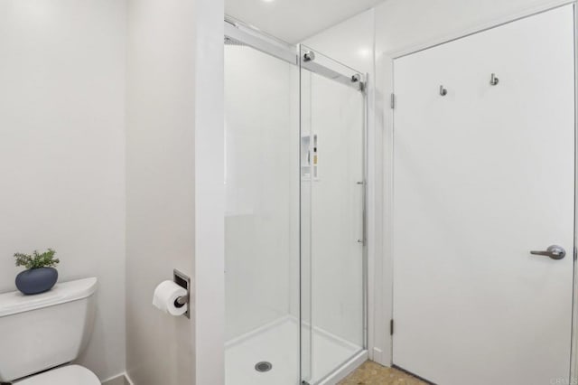 bathroom featuring an enclosed shower and toilet